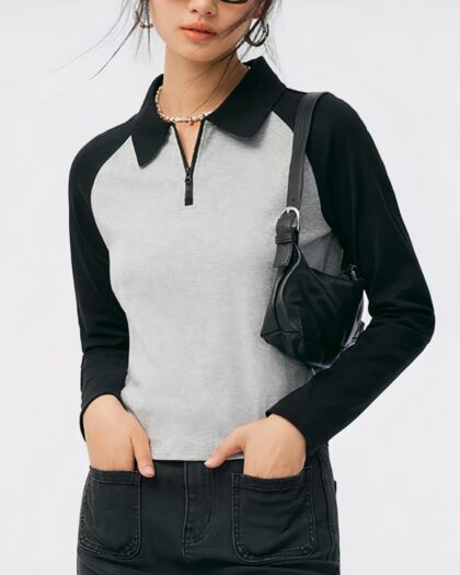 Polo manches longues gris et noir avec fermeture éclair, porté par une femme