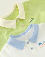 On voit deux polos superposés : un vert et un blanc. Ils sont pour bébé.