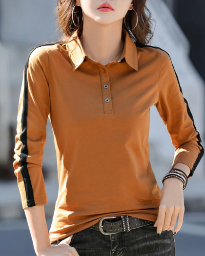 Polo orange avec une bande noir sur les manches longues. Porté par une femme