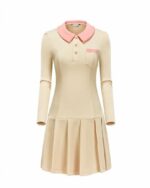 Photo d'une robe polo plissée à manches longues beige au col, boutons et revers de poche poitrine roses le tout sur un fond blanc