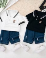 On voit deux ensembles composés d'un polo manches courtes pour bébé garçon : un bleu marine et un blanc. Et un short en jean.