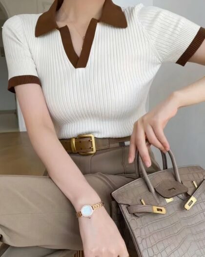 Polo beige et marron manches courtes . Porté une femme en pantalon beige et portant un sac à main