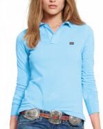 Polo bleu ciel à manches longues avec un petit drapeau anglais. Porté par une femme