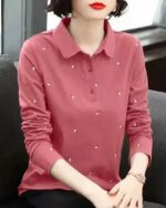 Polo rose brodé à manches longues porté par une femme