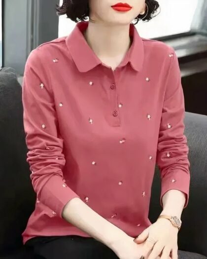 Polo rose brodé à manches longues porté par une femme