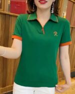 Femme portant un polo brodé vert à manches courtes.