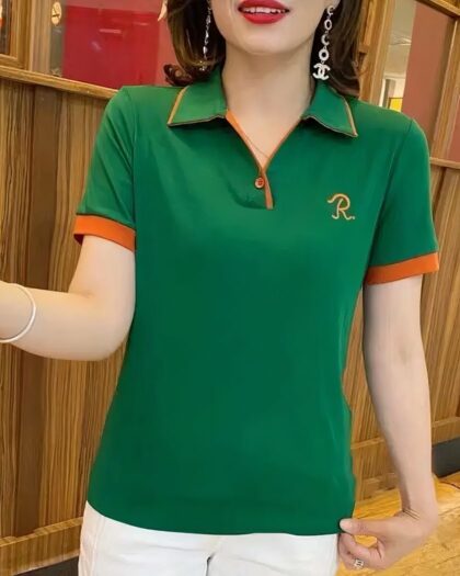 Femme portant un polo brodé vert à manches courtes.