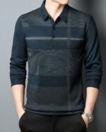 Homme portant un polo à manches longues et carreaux sur fond gris.