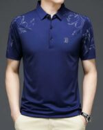 Homme portant un polo bleu à manches courtes sur fond gris.