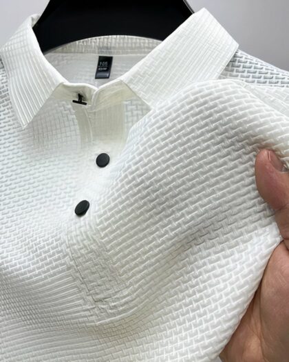 Polo blanc en tissu gaufré sur un ceintre.