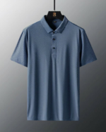 Photo d'un polo de golf infroissable gris à manches courtes sur un cintre en bois le tout sur fond gris foncé