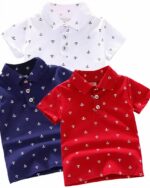 Sur fond blanc, on voit trois polos pour enfant, imprimé d'ancres marines. Il y en a un blanc, un bleu et un rouge.