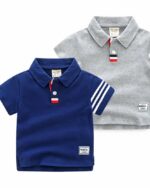 Sur fond blanc, on voit deux polos pour bébé : l'un bleu marine, l'autre gris.