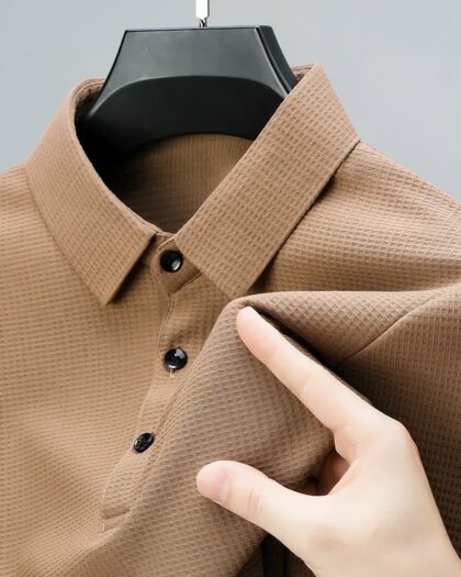 Haut de polo à manches courtes sur un ceintre.