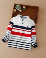 Sur fond beige on voit un polo manches longues rayé pour enfant.