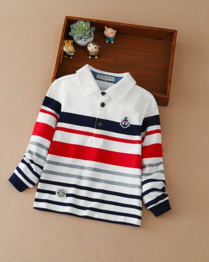 Sur fond beige on voit un polo manches longues rayé pour enfant.