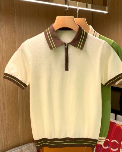 Un polo vintage zippé biege pour homme ur un cintre dans une buanderie devant un polo vert.