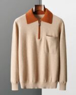 Photo d'un pull polo zippé bicolore beige et marron avec poche poitrine présenté sur cintre en bois marron foncé le tout sur un fond gris clair à droite et gris foncé à gauche