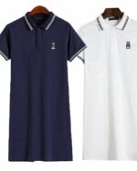 Photo de deux robes polo une bleu marine et une blanche sur cintres cols et bords des manches avec une double rayure de couleur opposée le tout sur un fond blanc