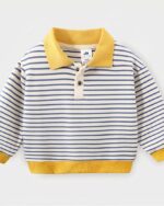 On voit un polo manches longues rayé pour petit garçon. Le col est jaune.