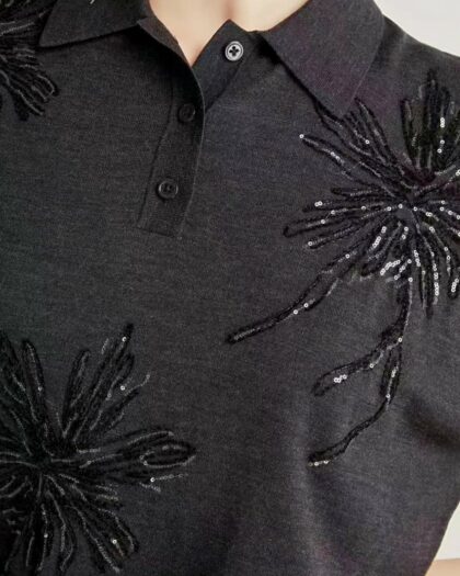 Photo d'un buste de femme portant un polo noir brodé de soie et de strass