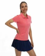 Femme portant un polo rose à manches courtes sur fond blanc.