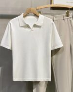 Polo blanc à manches courtes sur un ceintre.