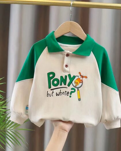 O, voit un polo manches longues blanc et vert avec une inscription de dessin animé sur le torse