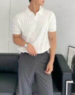 Homme portant un polo blanc sans bouton en tricot.