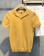 Polo sans bouton à manches courtes sur un ceintre.