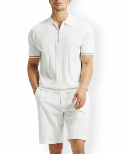Homme portant un polo blanc zippé avec un liseré marron sur le bord des manches, et un bermuda blanc.