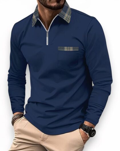 Homme portant un polo à manches longues bleu marine, avec un col à carreaux zippé et un détail poche poitrine à carreaux également