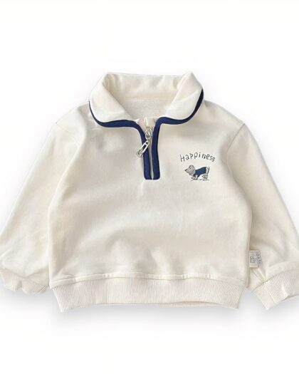 Polo blanc zippé avec un liseré bleu autour du col et du zip. Il y a une broderie avec un un petit chien et "hapiness" écrit