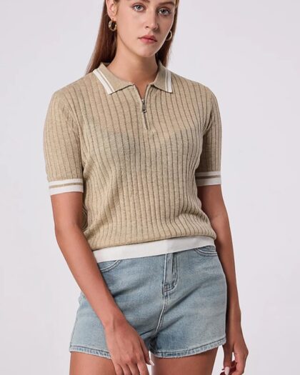 Femme qui porte un polo beige à manches courtes et un col zippé, en mailles côtelées