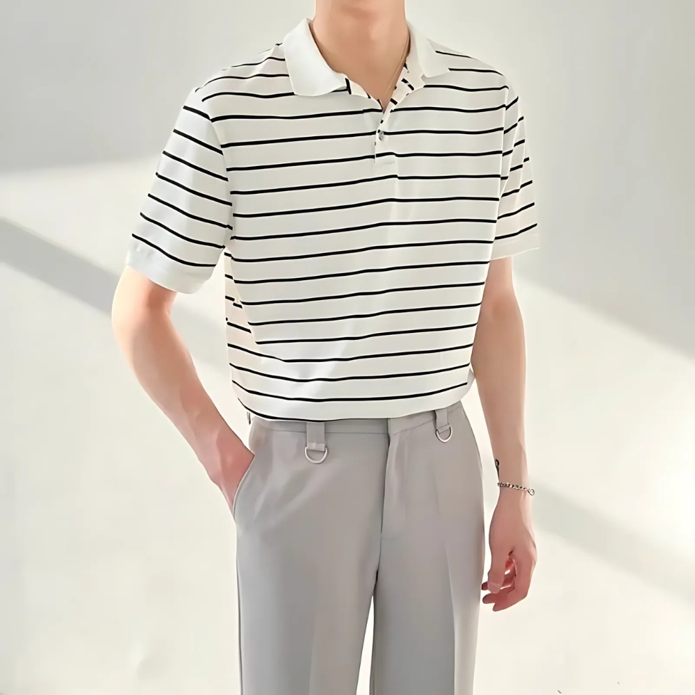 Polo marinière blanc et noir porté par un homme sur fond blanc